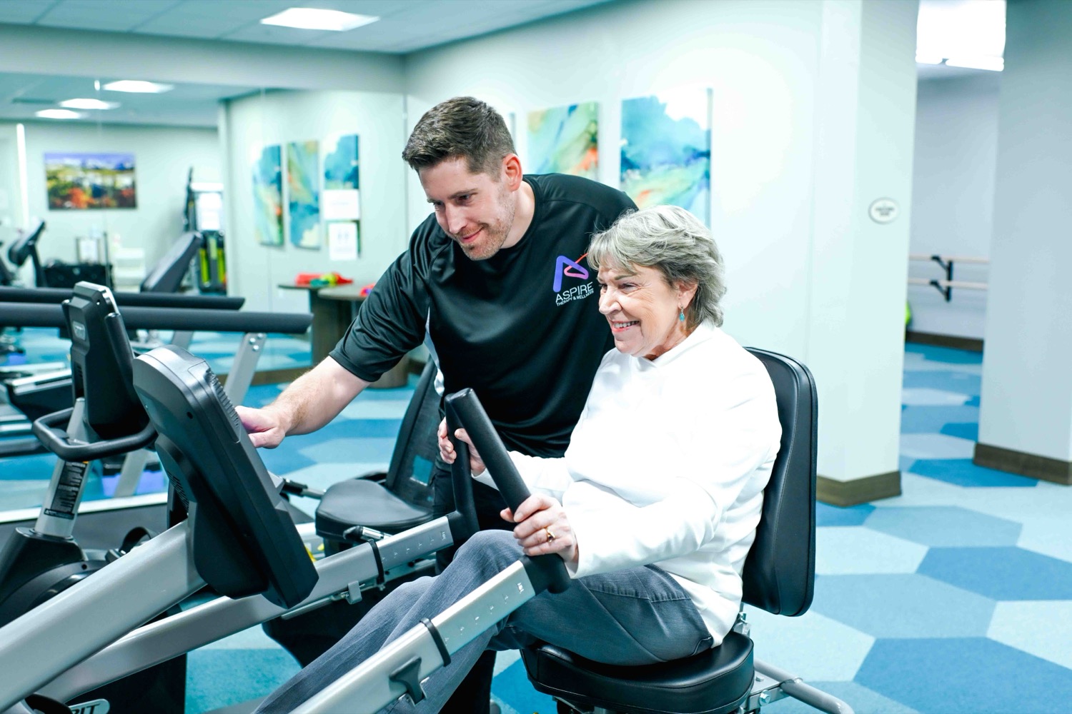 Wellness for Life — ASPIRE trainer working with a senior on a recumbent bike